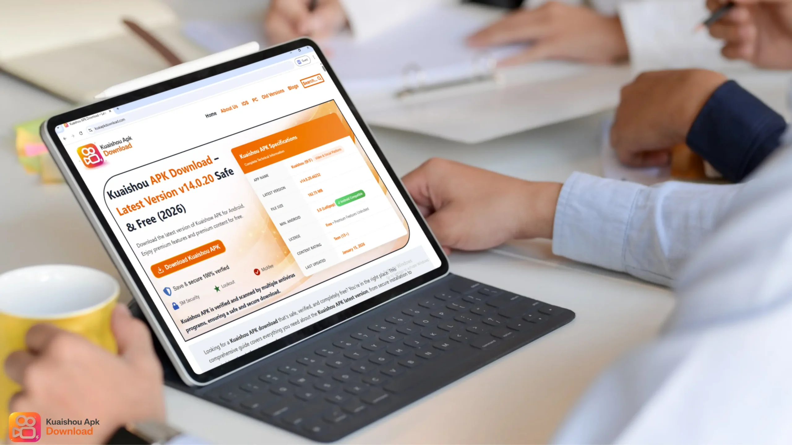 A person using a tablet with a keyboard attachment in an office setting. The screen displays a website titled "Kuaishou APK Download," showing technical specifications for the app version v14.0.20 and a prominent orange download button.
